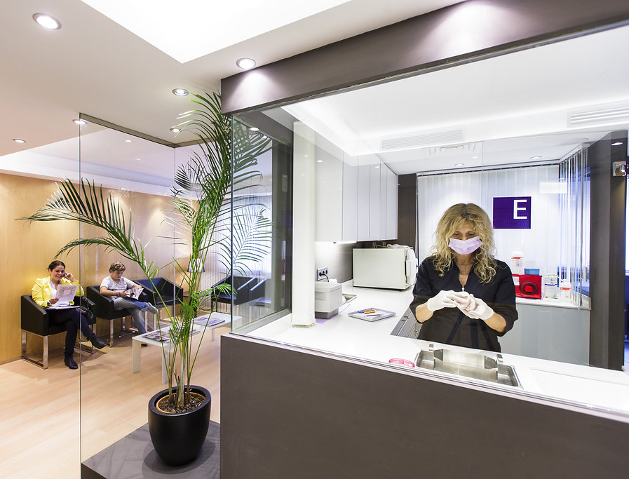 Sala de Espera y Sala de Esterilización de la Clínica Dental Ochogavía en Palma con dos pacientes esperando su turno y una enfermera trabajando