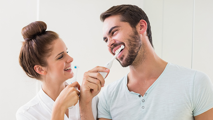 pareja cepillándose los dientes según consejos de la clínica dental ochogavía