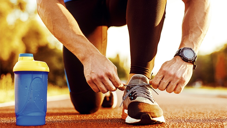 Corredor con buena salud dental atandose los cordones antes de comenzar a correr